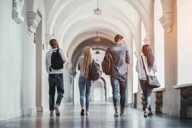 Group of students walking down a hall with backpacks.