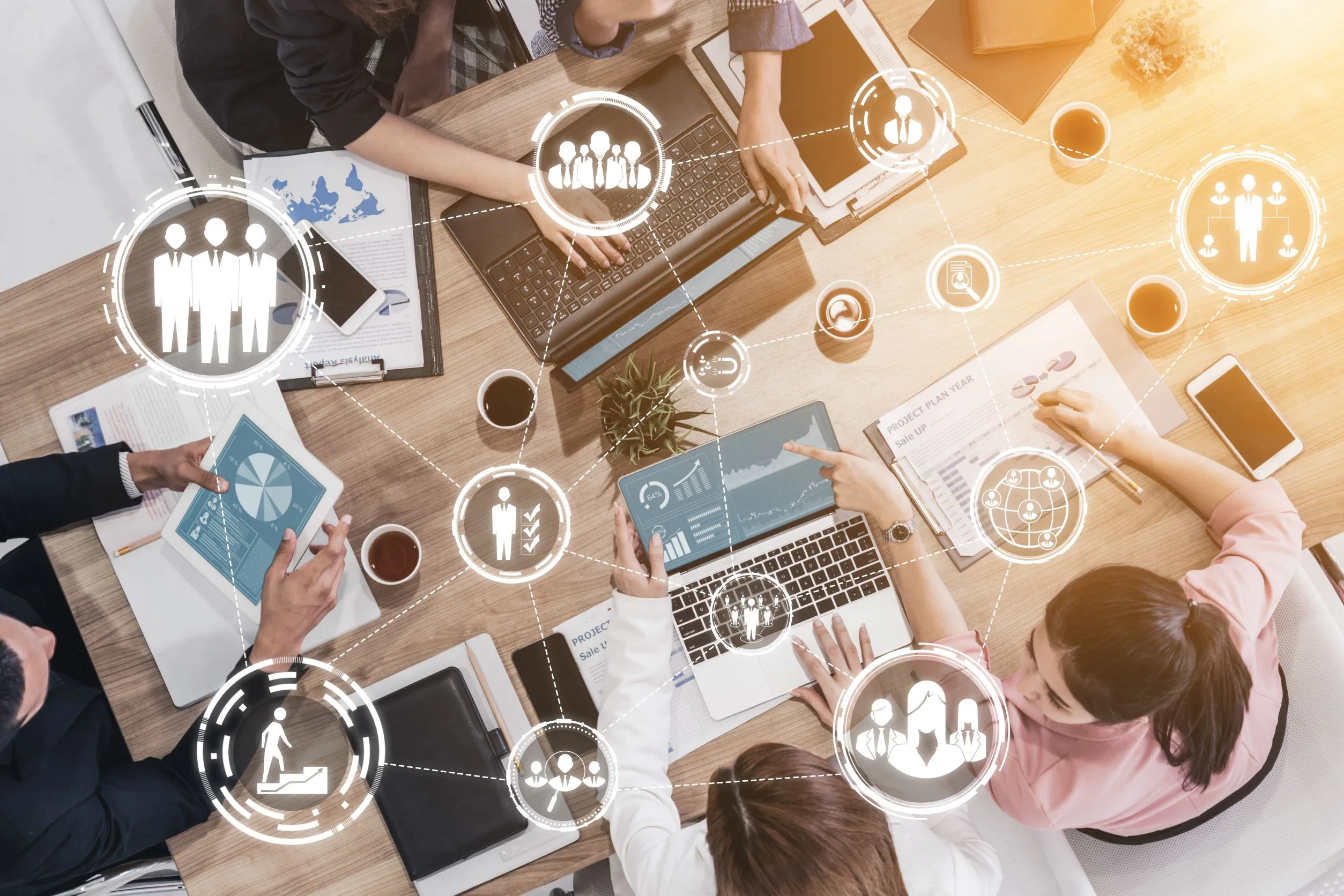 Professionals working at a table with icons floating to represent platform integrations.