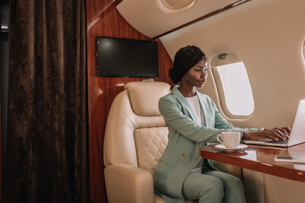 A woman working on a laptop in a high class airplane
