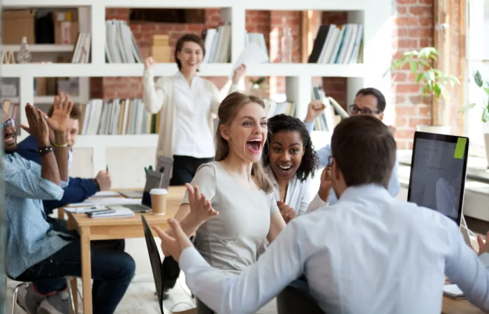 Excited diverse business team celebrating good news